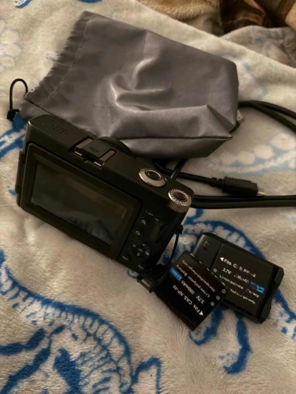 Black Compact Digital Camera with Lens Cap and Charger